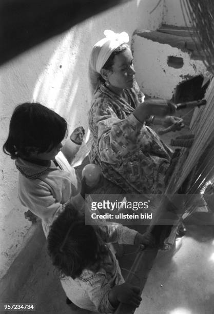 Eine Teppichweberin m it ihren Kindern bei der Arbeit, audfgenommen in einem Dorf bei Kairo 1972.