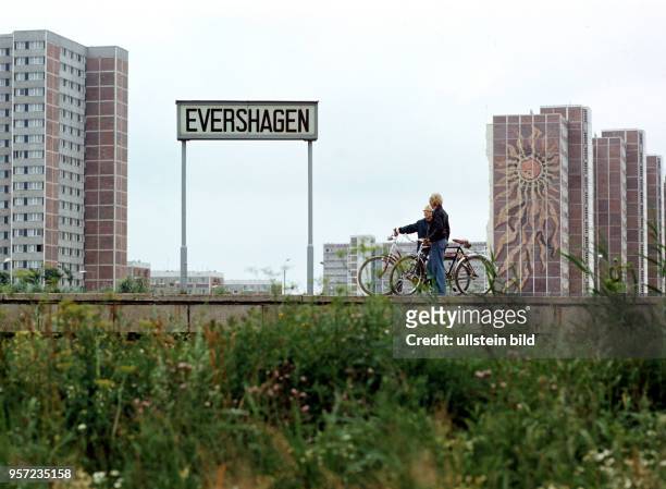 Zwei Männer unterhalten sich auf dem Bahnsteig der S-Bahnstation Evershagen in Rostock, im Hintergrund die Neubauten von Rostock-Evershagen mit einem...