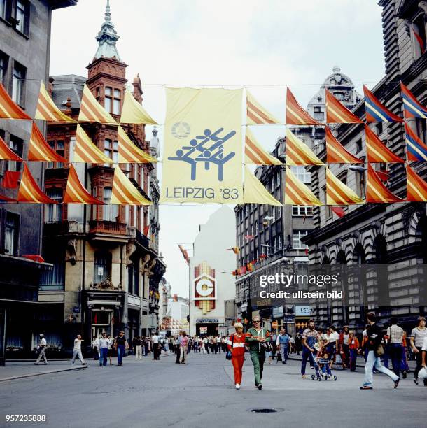 In einer Straße in der Innenstadt von Leipzig hängen Werbe-Fahnen für IX. Kinder- und Jugendspartakiade der DDR, die vom 25.-31. 07.1983 in Leipzig...