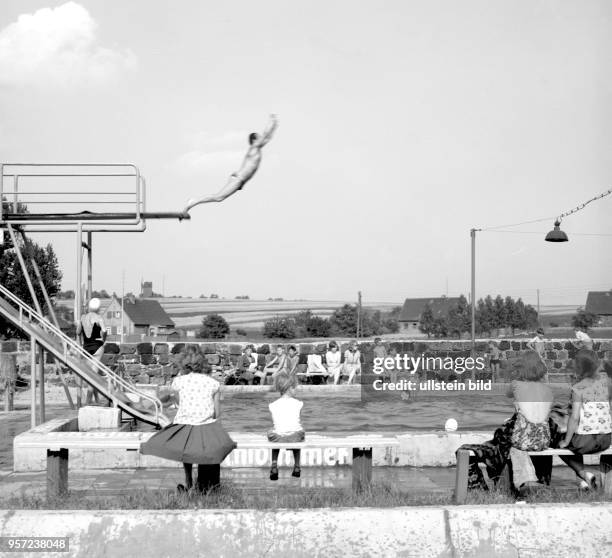 Ein Mann springt vom Turm, Alt und Jung im Freibad im Gemeindeverband Polleben, Kreis Eisleben, aufgenommen im Sommern 1966.