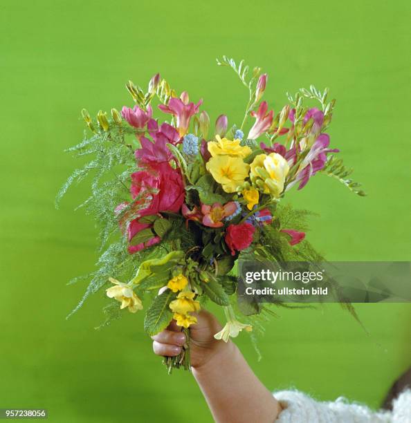 Ein Kind hält in einer Farbaufnahme einen Blumenstrauß in der Hand, aufgenommen im März 1972 in Berlin.