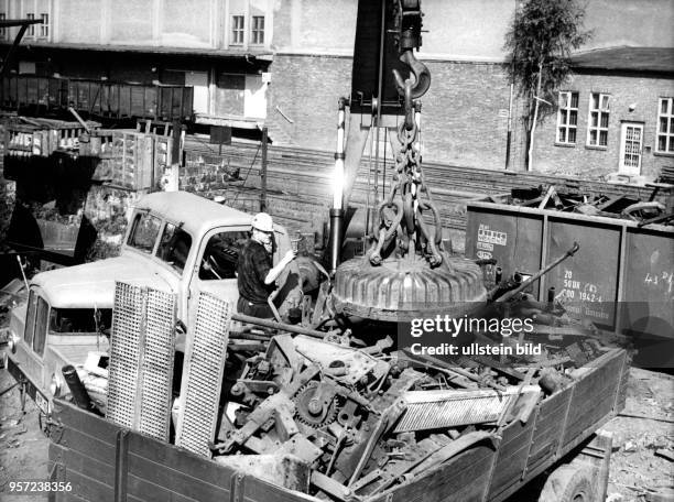 Aus einem Lkw wird mit einem Magnetkran in einem Betrieb in Dresden Schrott in bereitgestellte Eisenbahnwaggons verladen, aufgenommen 1970. Der...