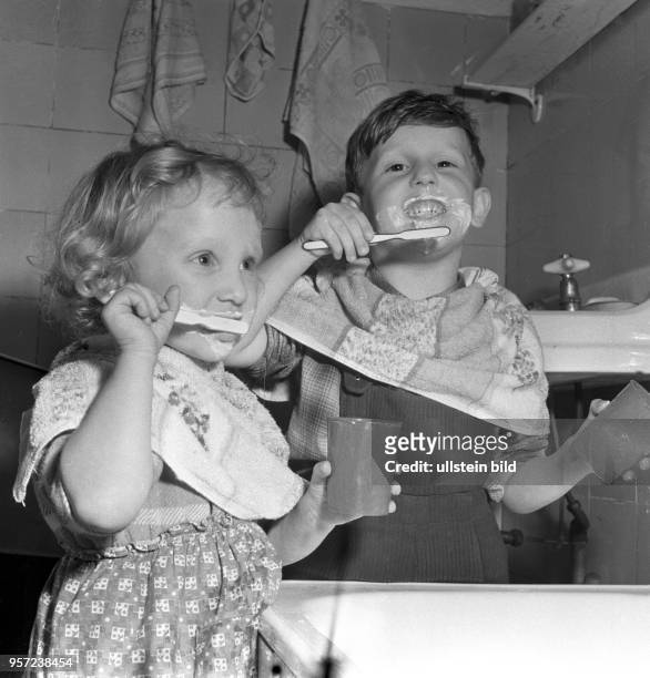 Ein Junge und ein Mädchen mit Zahnbürsten beim Zähne putzen, undatiertes Foto von 1959.