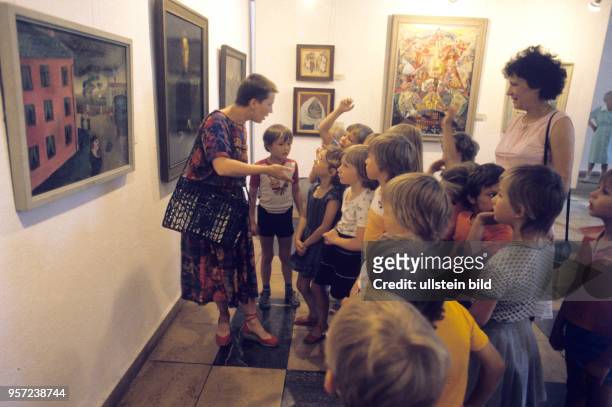 Mädchen und Jungen eines Kindergartens besuchen die Galerie Junge Kunst in Frankfurt und sprechen mit ihren Erzieherinnen über die ausgestellten...