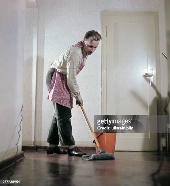 Speziell für die DDR-Frauenzeitschrift "Für Dich" gestellt wurde diese Szene eines wischenden Hausmannes, das mit Fragezeichen "Pantoffelheld?" ins...