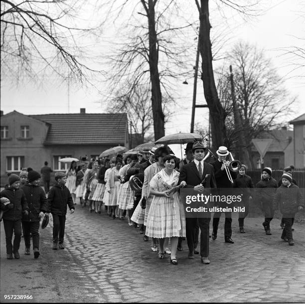 In Trachten und Anzug ziehen junge Frauen und Männer am durch das Dorf Limberg zum sorbischen Brauch Zapust als Teil der Fastnacht in der...