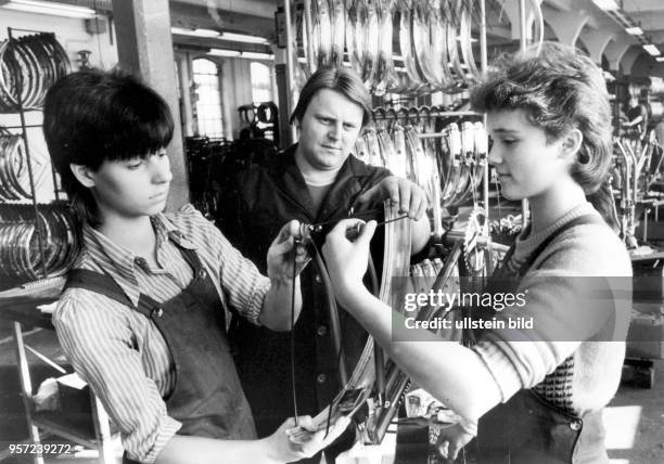 Unter Beobachtung montieren zwei Schülerinnen im VEB Fahrradwerk Neukirch ein Fahrrad, aufgenommen 1986. Unterrichtstag in der sozialistischen...