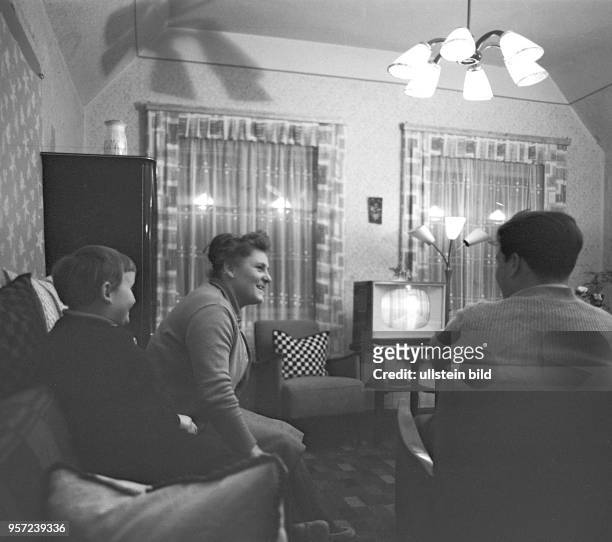 Eine Familie beim abendlichen Fernsehen im Wohnzimmer im Ort Körbelitz bei Magdeburg, aufgenommen im Frühjahr 1964.