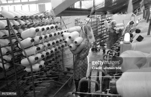 In diesem Betrieb in Mühlhausen wird Kammgarn produziert, aufgenommen 1984. Das produzierte Garn wird, nachdem es auf Spulen gewickelt wurde, von...