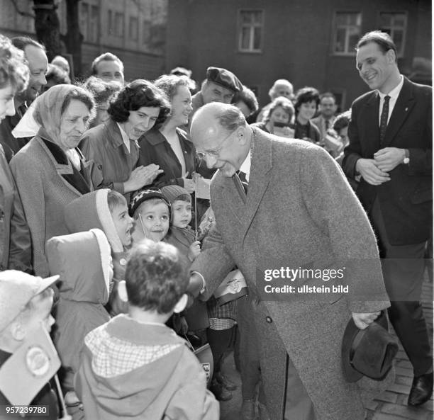 Walter Ulbricht, SED-Chef und Staatsratsvorsitzender der DDR, begrüßt Kinder, die mit kleinen Fähnchen am Straßenrand zur Begrüßung des...