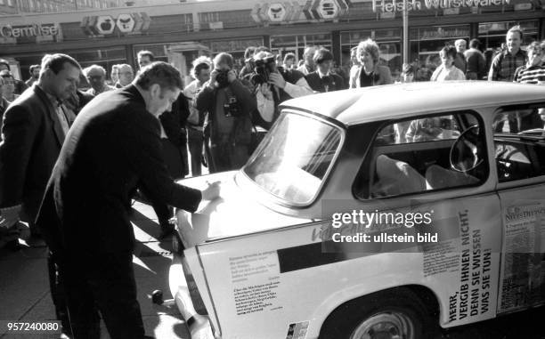 Zur Volkskammerwahl am 18.3.1990 schreibt Dresdens Oberbürgermeister Wolfgang Berghofer vor dem Wahllokal am Altmarkt in Dresden sein Autogramm auf...