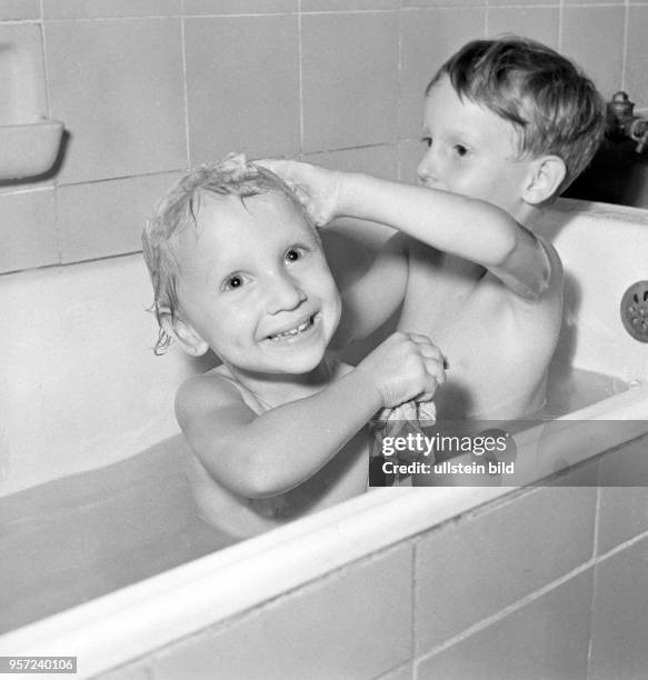 Ein kleines Mädchen und ein kleiner Junge zu Hause in einer privaten Wohnung in Berlin in einer Badewanne beim Haare waschen, undatiertes Foto vom...