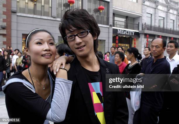 Oktober 2009 / China - Peking/ Ein junges Paar besucht die sanierte alte Einkaufsstraße Qianmen Dajiie in Peking. Das Gebiet der Straße südlich vom...