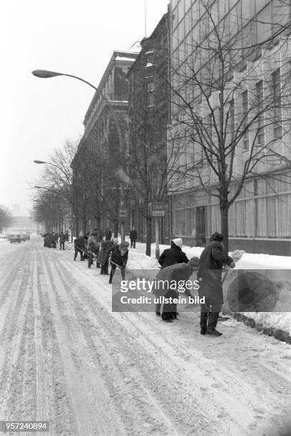 Freiwillige schaufeln Schnee von der Fahrbahn der Straße Unter den Linden, undatiertes Foto vom Februar 1979. Extreme Kälte und viel Schnee...