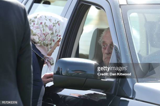 Queen Elizabeth II speaks to Prince Philip, Duke of Endinburgh through the car window at the third day of the Royal Windsor Horse Show on May 11,...