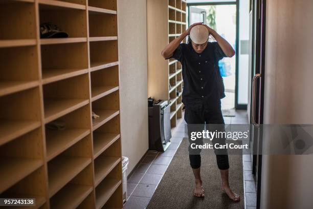 An Indonesian Muslim adjusts his taqiyah cap as he arrives to attend Friday prayer at Indonesia-Tokyo Mosque on May 11, 2018 in Tokyo, Japan....