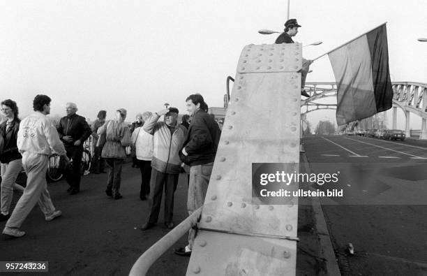 Menschen überqueren auf ihrem Weg zum Grenzübergang Bornholmer Straße die Bösebrücke , aufgenommen im November 1989 in Berlin. Auf einem...