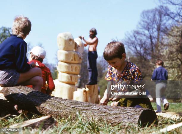 VolkskÃ_nstler gestalten zusammen mit Kindern einen Holzspielplatz aus Holz in Neustadt in Sachsen , aufgenommen 1983. Foto : Reinhard Kaufhold