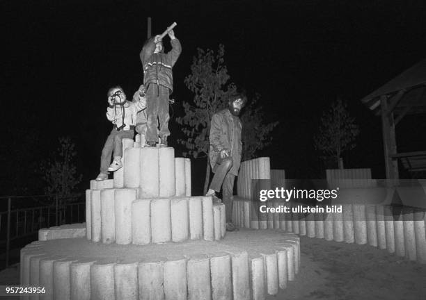 Ein Mann und drei Kinder auf dem nächtlichen Heimweg von einem Straßenfest im Wohngebiet Ernst-Thälmann-Park in Berlin , aufgenommen 1986. Das...