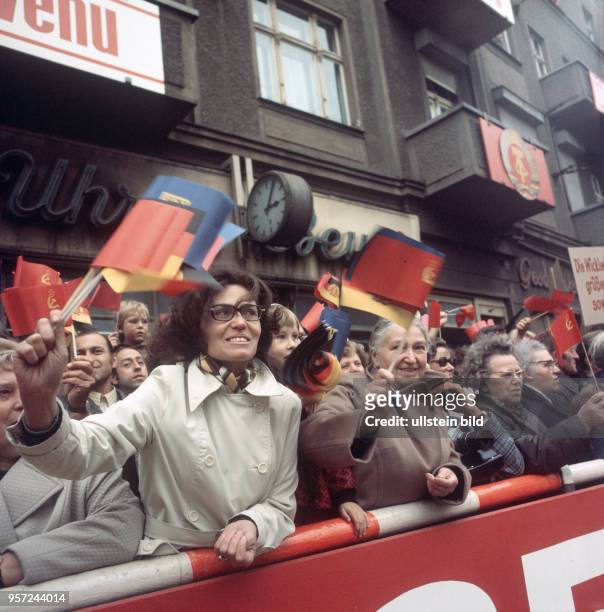 Einwohner von Berlin stehen am Straßenrand und winken mit Papierfähnchen, undatiertes Foto vom Oktober 1974. Zu den Feierlichkeiten zum 25. Jahrestag...