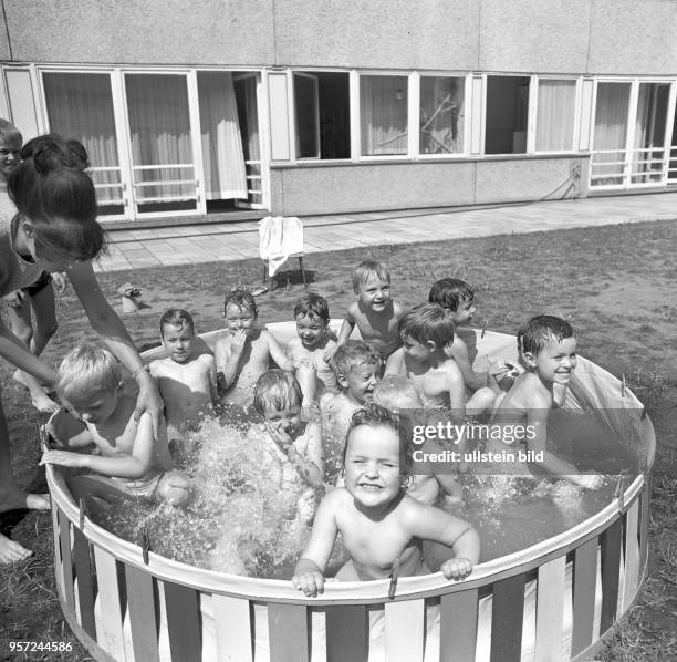 Mädchen und Jungen sitzen in einem Planschbecken in einem Kindergarten im Cottbuser Neubaugebiet IX, undatiertes Foto vom Juli 1972. Hier wohnen...