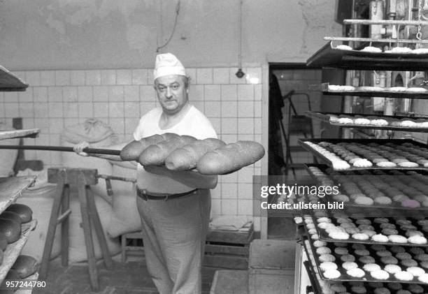 Ein Bäcker mit Broten in einer Bäckerei in Saßnitz, undatiertes Foto von 1981.