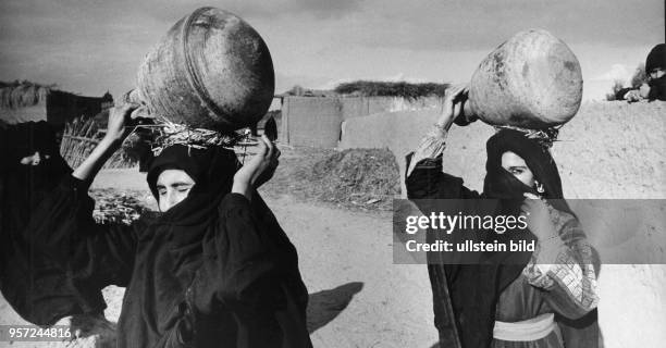 Verschleierte Frauen aus einem Dorf bei Luxor tragen Wasserkrüge auf ihren Köpfen, aufgenommen 1972.