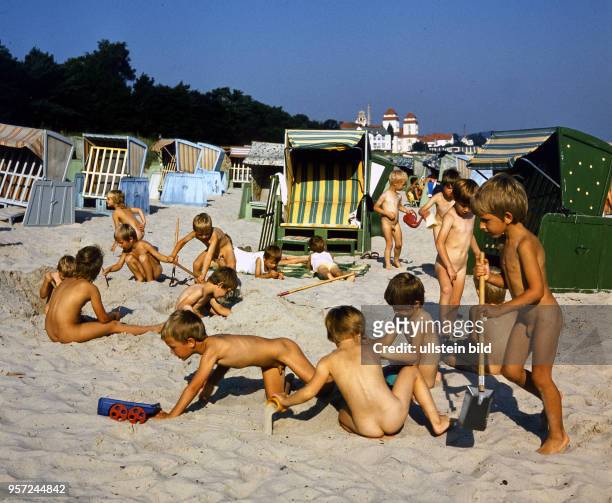 Spielende Kinder am Sandstrand von Binz auf der Insel Rügen an der Ostsee, aufgenommen im Sommer 1987.