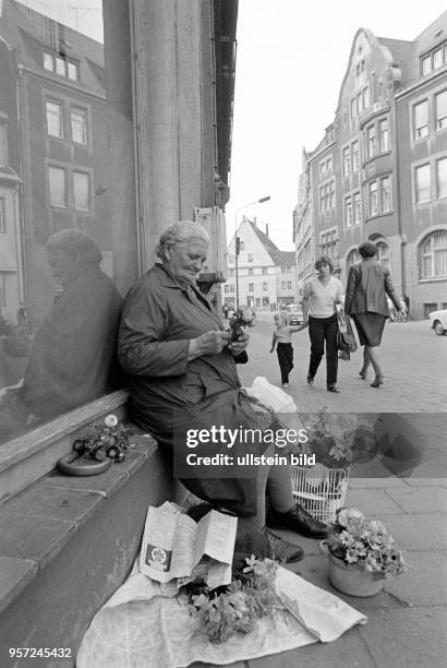 Eine alte Frau verkauft am Straßenrand am Marktplatz Blumen, aufgenommen am in der Lutherstadt Eisleben . Vielleicht kann sie die ankommende Mutter...