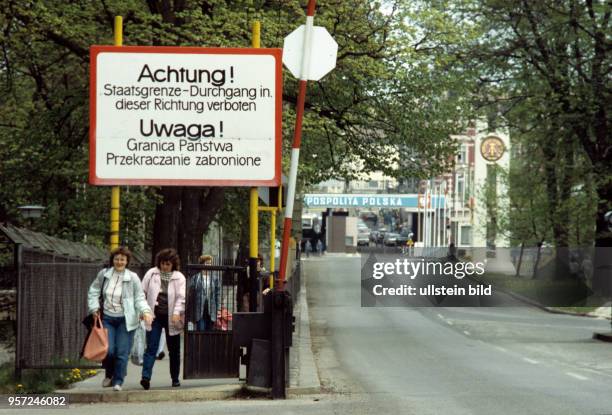 "Achtung Staatsgrenze - Durchgang in diese Richtung verboten" steht auf einem großen Schild an einer Straße in Görlitz, auf der Frauen aus Richtrung...