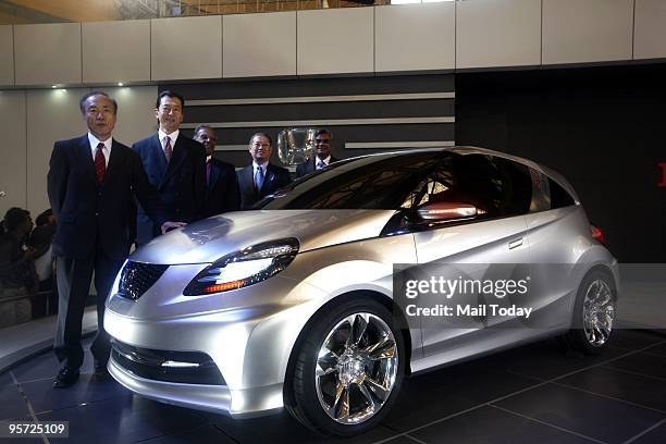 Honda senior officials pose next to a new small concept car at the 10th Auto expo in New Delhi on Thursday, January 7, 2010.