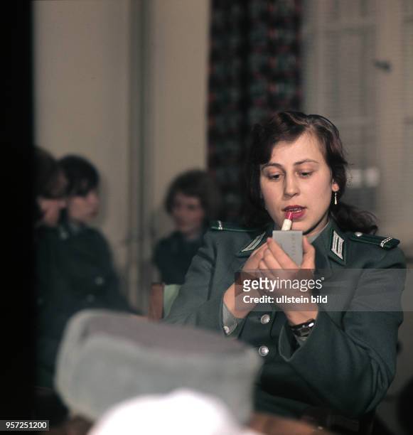 Eine Verkehrspolizistin schminkt sich mit Lippenstift die Lippen, aufgenommen 1966 in Leipzig. Auch der Beruf in der Volkspolizei stand den Frauen in...