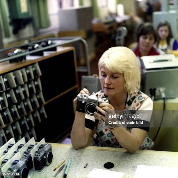Im VEB Pentacon Kombinat in Dresden kontrollieren Arbeiterinnen die fertig montierten Kameras - hier eine Praktica L2 - auf ihre Qualität und...