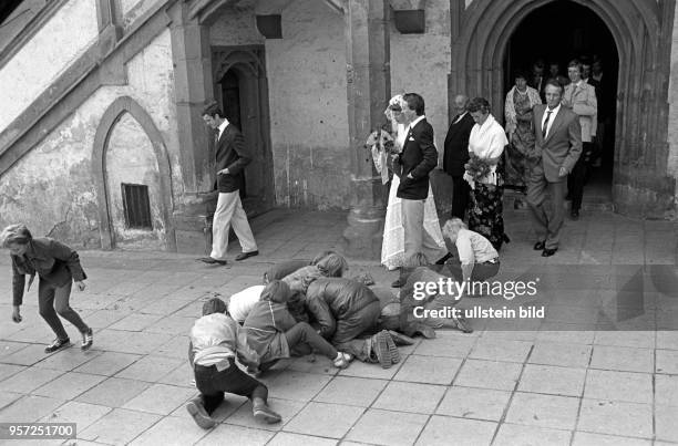 Das frisch getraute Brautpaar verlässt mit Freunden und Familienangehörigen das Rathaus am Markt, aufgenommen im September 1981 in der Lutherstadt...