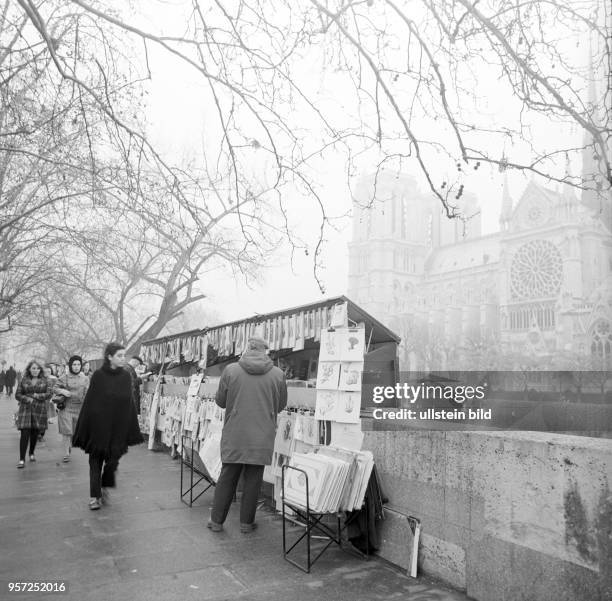 Künstler bieten am Seine-Ufer ihre Zeichnungen und Gemälde an, aufgenommen im November 1970 in Paris. Im Hintergrund ist die Kathedrale Notre-Dame de...