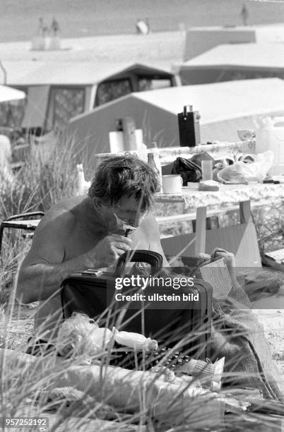 Ein Camper erledigt seine morgendliche Rasur inmitten der Dünen im Ostseebad Prerow auf dem Darß, aufgenommen im Juli 1983. Der Zeltplatz in Prerow...