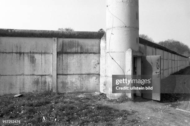 Eine offene Tür als Zugang zu einem Beobachtungsturm an einer Betonmauer der DDR-Grenzanlagen der DDR-Grenztruppen an der innerdeutschen Grenze...