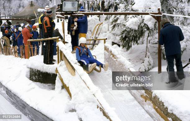 Zur VII. Kinder- und Jugendspartakiade im Februar 1979 startet ein junger Rodler auf seinem Schlitten die Abfahrt auf der vereisten Rennrodelbahn in...