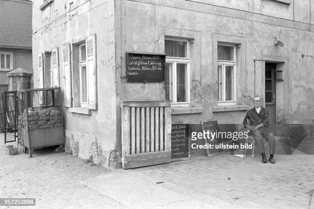 Der Händler Hans Hofmann sitz im Juli 1978 vor seinem kleinen Laden in Magdeborn und wartet auf die letzten Kunden, undatierets Foto vom Juli 1978....