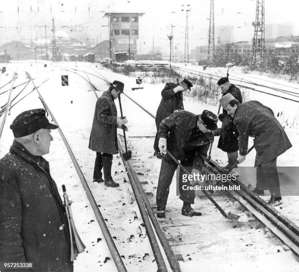Männer befreien am Weichen am Schienennetz vor dem Dresdner Hauptbahnhof vom Schnee. Oftmals wurden im Winter Mitarbeiter aus Betrieben zu...