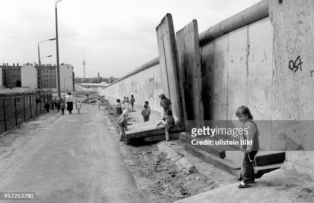 Die Berliner Mauer dient im Mai 1990 zwischen zwischen Prenzlauer Berg im Osten und Wedding im Westen als Kinderspielplatz. Das Bauwerk hat...