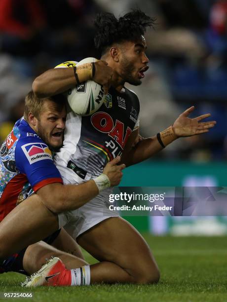 Christian Crichton of the Panthers is tackled by Nathan Ross of the Knights during the round 10 NRL match between the Newcastle Knights and the...