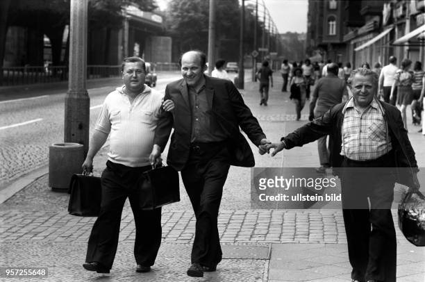 Eine lustige Männerrunde auf dem Fußgängerweg in der Schönhauser Allee im Berliner Stadtbezirk Prenzlauer Berg, aufgenommen 1977.