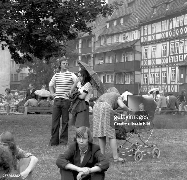 Eine Familie mit Kinderwagen beim historischen Krämerbrückenfest an den Häusern an der Krämerbrücke in Erfurt, undatiertes Foto von 1977.