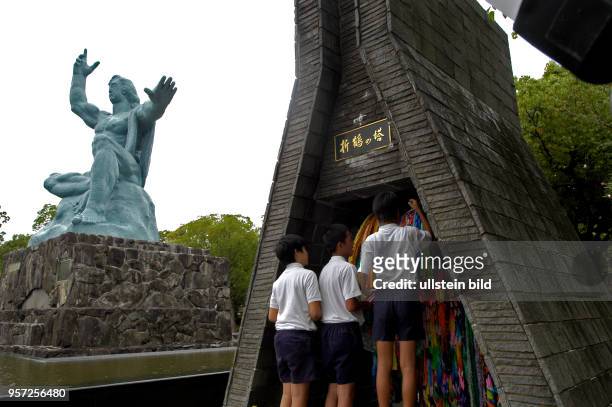 Japan / Nagasaki /Japanische Schüler im Friedenspark vor der 10 Meter hohe Friedensstatue von Kitamura Seibo in der Atombomben-Gedenkstätte von...