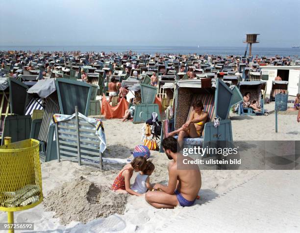 Dicht gedrängt stehen die Strandkörbe am Warnemünder Ostseestrand, an dem Jung und Alt ihre Ferien genießen, aufgenommen 1985. Im Hintergrund ein...