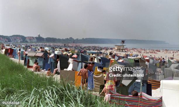Dicht gedrängt stehen die Strandkörbe am Warnemünder Ostseestrand, an dem Jung und Alt ihre Ferien genießen, aufgenommen 1985. Im Hintergrund ein...