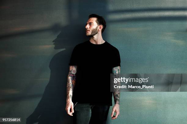 retrato de hombre joven tatuada con camiseta negra - camiseta fotografías e imágenes de stock