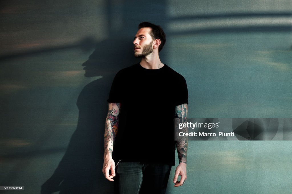 Portrait of tattooed young man with black t-shirt