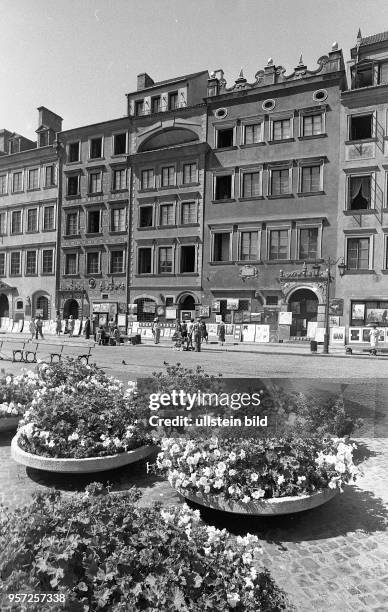 Blick auf große Blumenschalen vor historischen Gebäuden in der Warschauer Altstadt, aufgenommen 1975 in Polen.